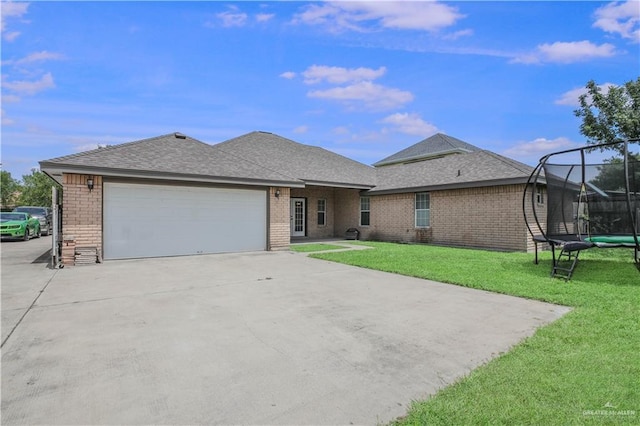 315 Oregano St, Edinburg, TX 78541 - single story home with a trampoline, a garage, a front lawn, driveway, and brick siding