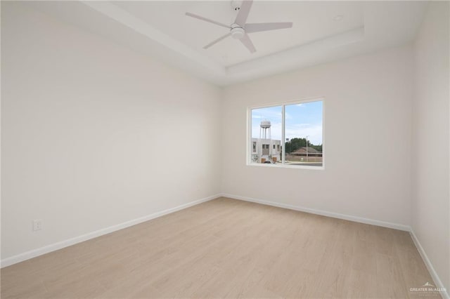1202 N Lincoln Ave, San Juan, TX 78589 - unfurnished room with light wood finished floors, a raised ceiling, baseboards, and ceiling fan