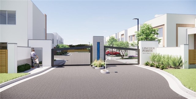 1202 N Lincoln Ave, San Juan, TX 78589 - view of asphalt road with a gate, curbs, street lighting, and a gated entry