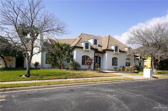 french country home with a front lawn