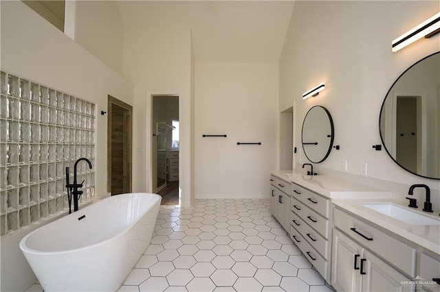 bathroom featuring vanity, a bath, tile patterned floors, and a high ceiling