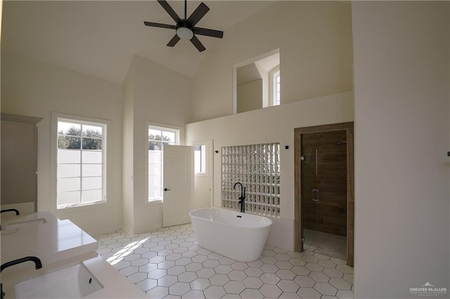 bathroom featuring tile patterned flooring, plus walk in shower, sink, and high vaulted ceiling