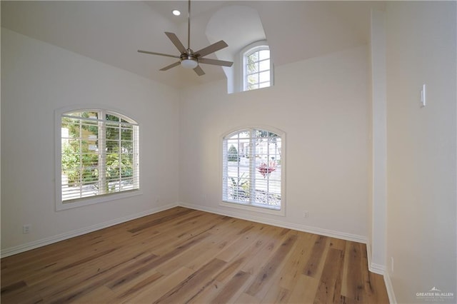 empty room featuring ceiling fan, a wealth of natural light, and light hardwood / wood-style floors