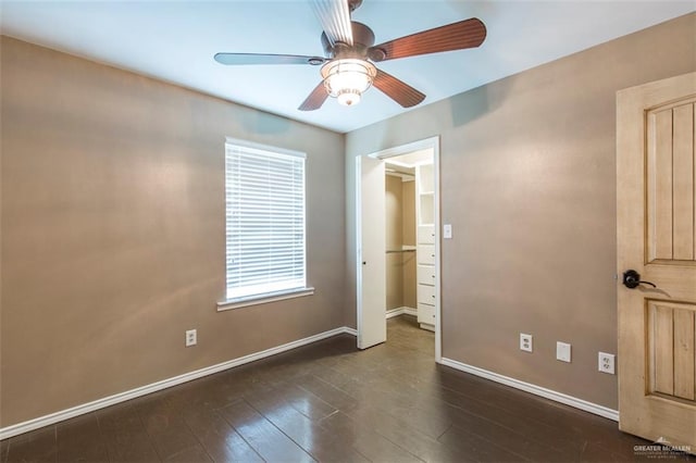 unfurnished bedroom with ceiling fan and dark hardwood / wood-style floors