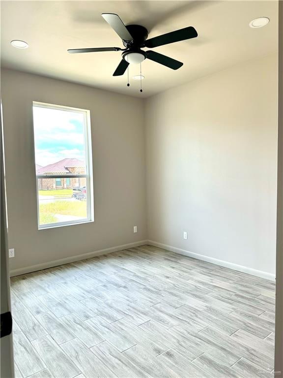 empty room with light hardwood / wood-style flooring and ceiling fan