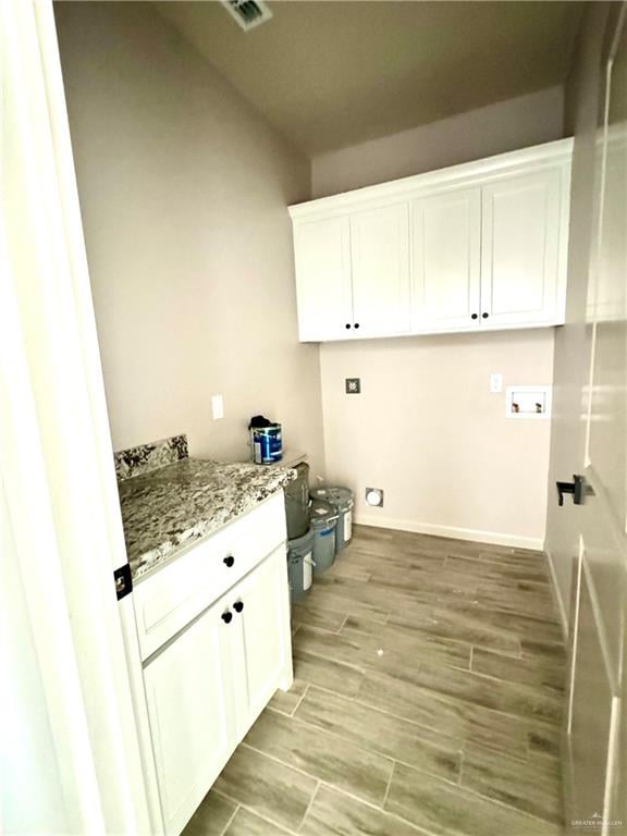 laundry room featuring cabinets, hookup for a washing machine, and light hardwood / wood-style flooring