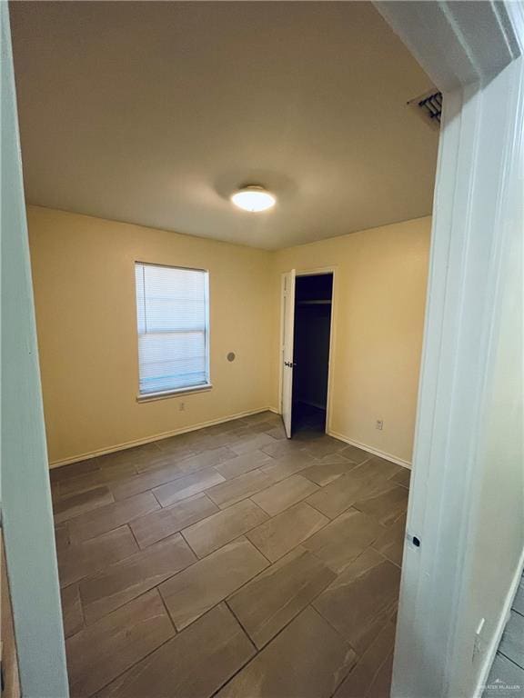 unfurnished room with wood tiled floor, visible vents, and baseboards