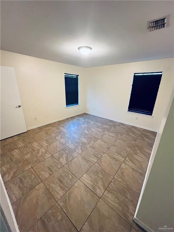 spare room featuring visible vents and baseboards