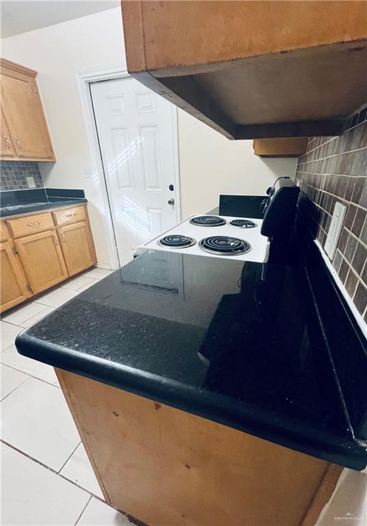 kitchen with light tile patterned floors and backsplash