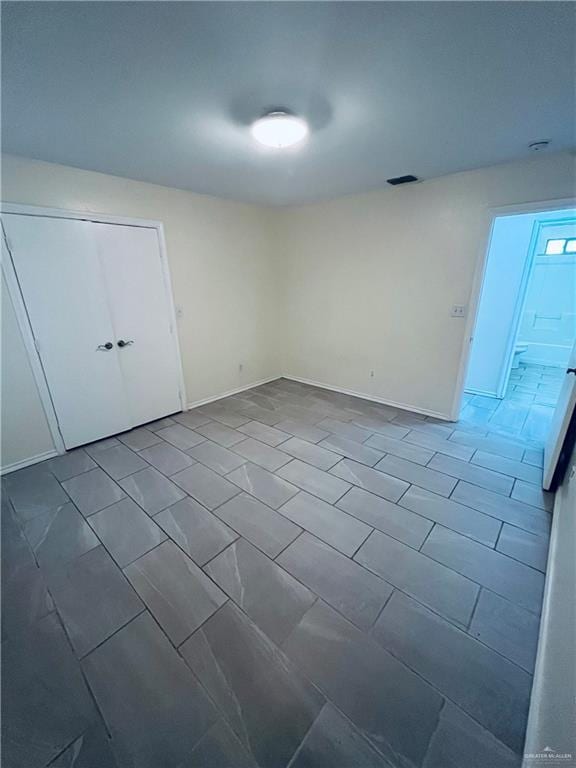 empty room featuring baseboards and visible vents