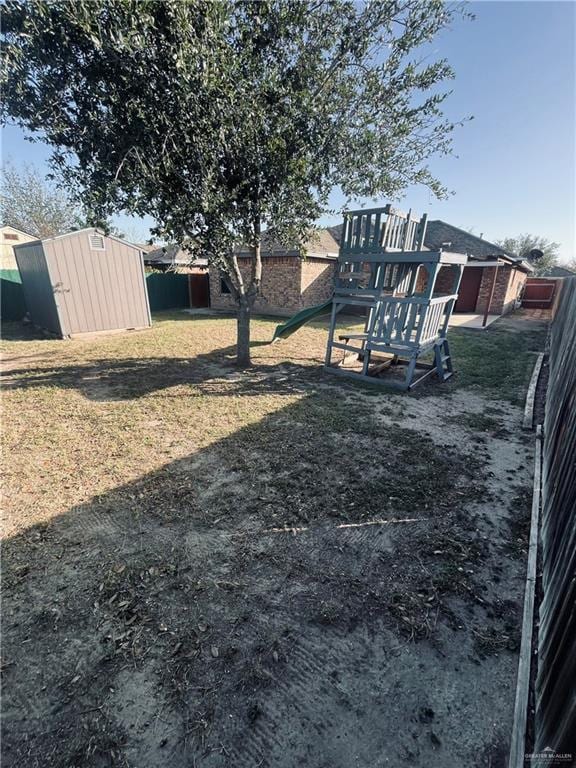 view of yard featuring a playground and a storage shed