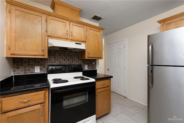 kitchen featuring stainless steel refrigerator, decorative backsplash, and electric range oven