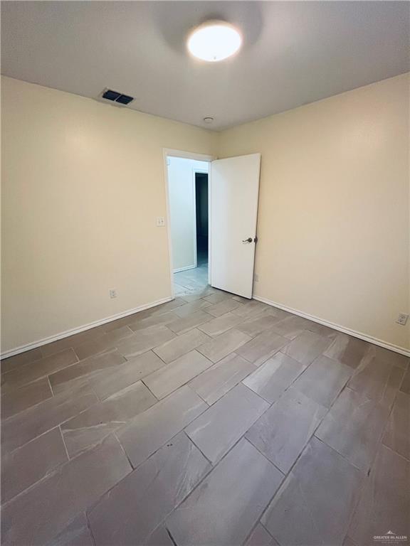 unfurnished room with visible vents and baseboards