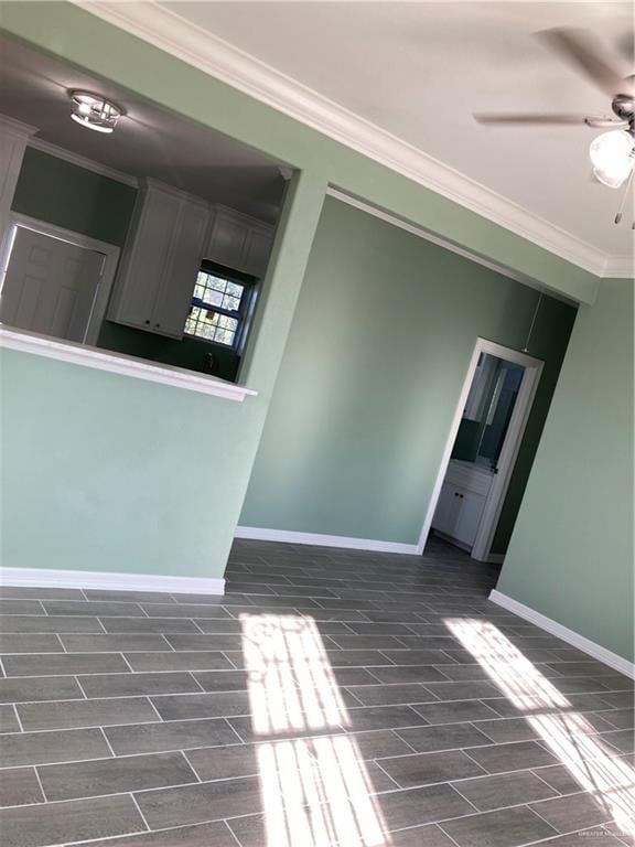 spare room with crown molding, ceiling fan, and dark wood-type flooring