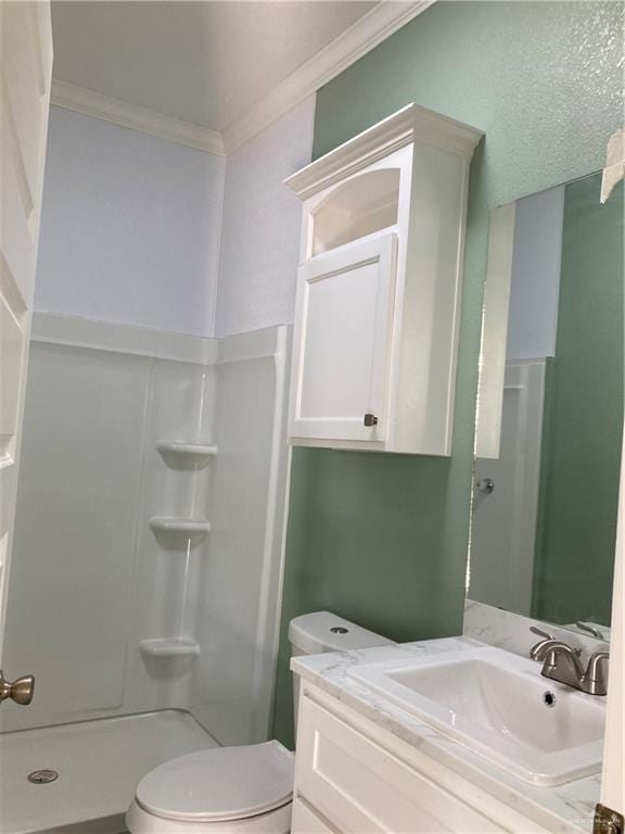 bathroom with crown molding, toilet, vanity, and walk in shower