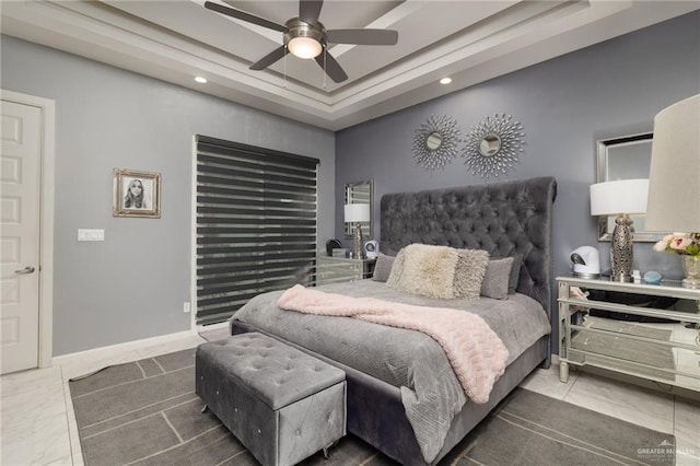 bedroom with a raised ceiling and ceiling fan