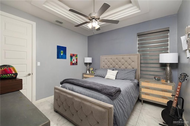 bedroom with a tray ceiling and ceiling fan