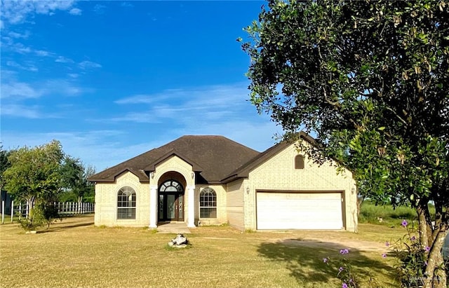 view of front of property with a front yard and a garage