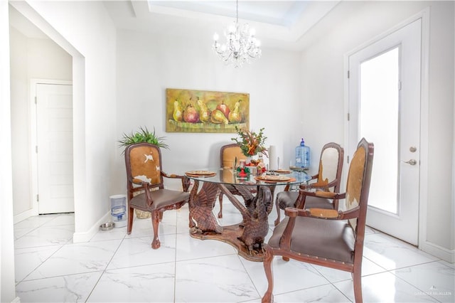 dining space featuring a raised ceiling and a chandelier