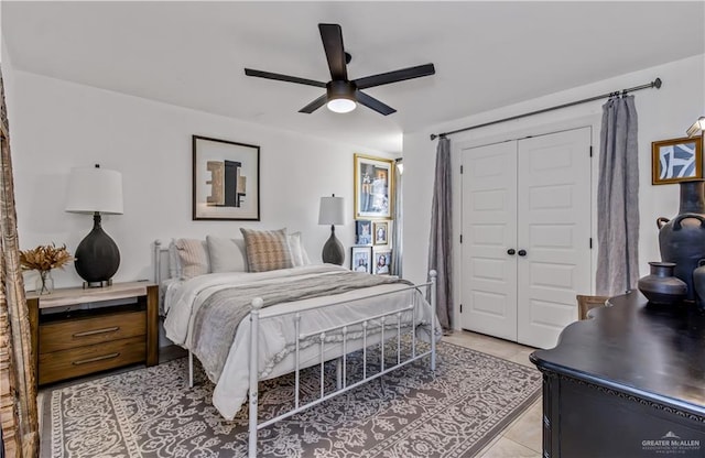 bedroom with ceiling fan, a closet, and light tile patterned floors