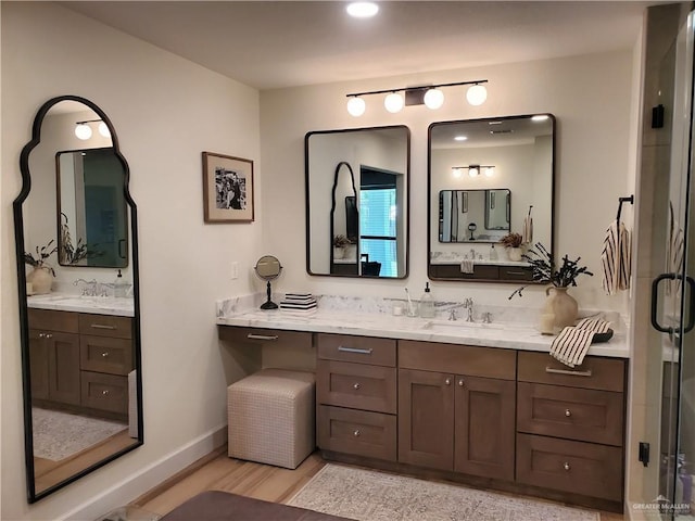 bathroom with wood-type flooring, vanity, and walk in shower