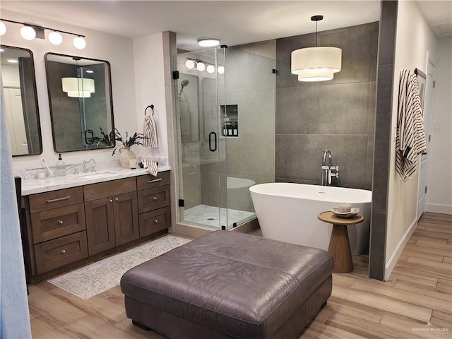 bathroom with vanity, wood-type flooring, and shower with separate bathtub