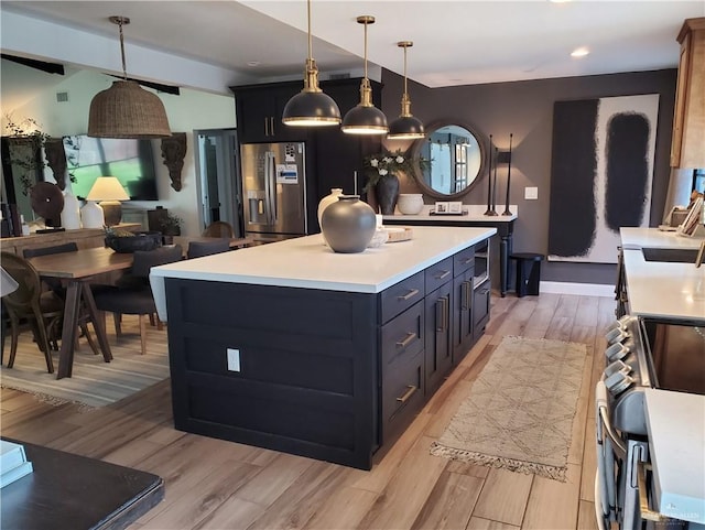 kitchen with range, decorative light fixtures, stainless steel fridge with ice dispenser, a center island, and light hardwood / wood-style floors