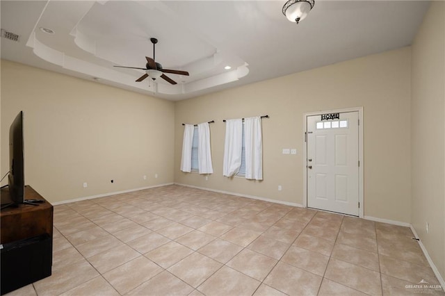 entrance foyer featuring a tray ceiling, ceiling fan, and light tile patterned floors