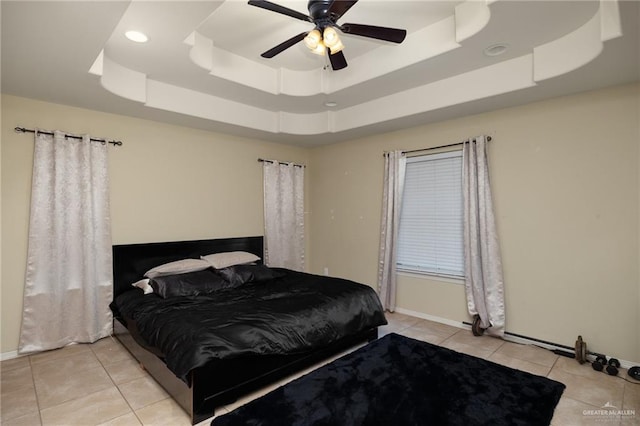 bedroom with light tile patterned floors, a raised ceiling, and ceiling fan