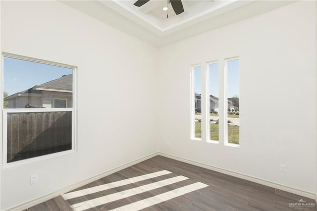 spare room featuring baseboards, wood finished floors, and a ceiling fan