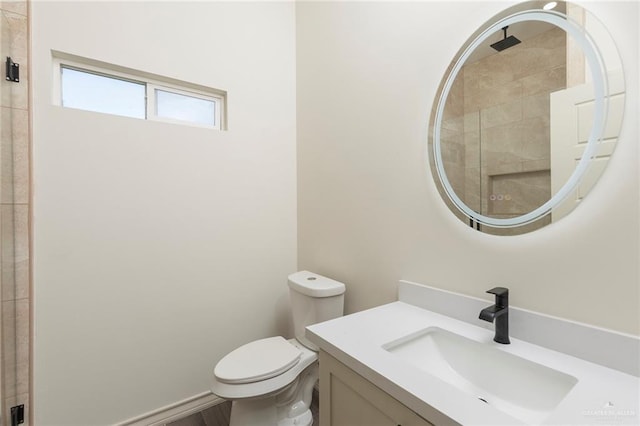 full bathroom featuring vanity, toilet, and tiled shower