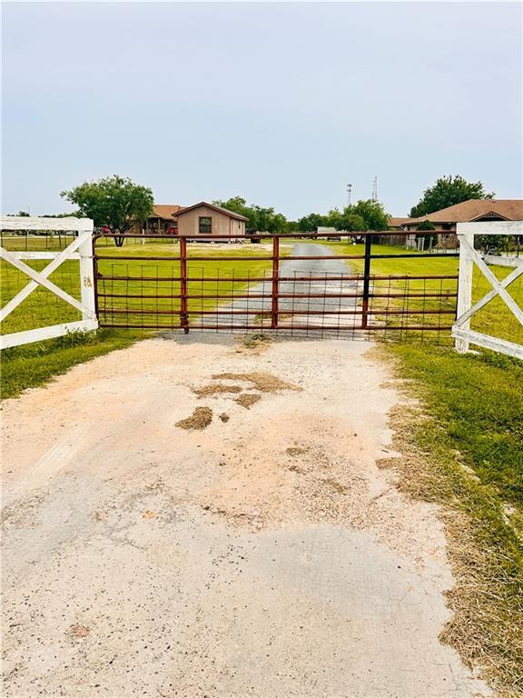 view of gate with fence and a yard