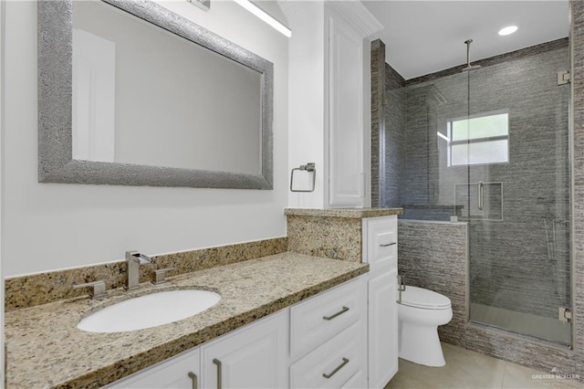 bathroom with tile patterned flooring, vanity, a shower with door, and toilet