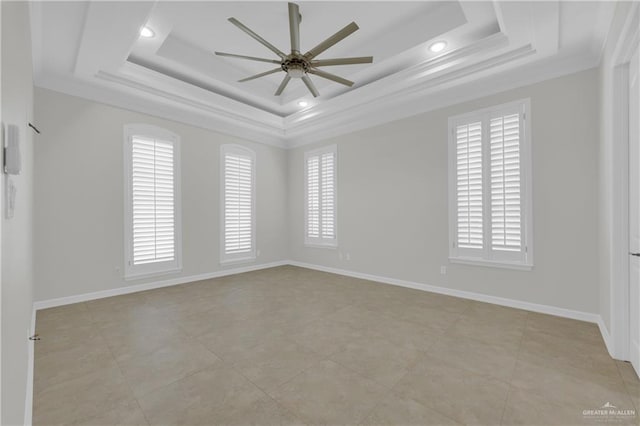 spare room with a raised ceiling, crown molding, and ceiling fan