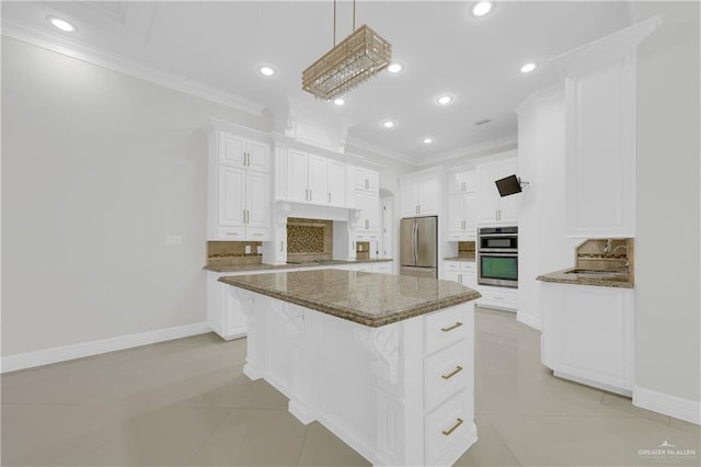 kitchen featuring tasteful backsplash, stainless steel appliances, white cabinets, dark stone counters, and a center island