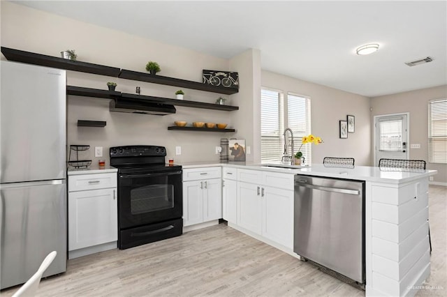 6009 Midcrown Dr, San Antonio, TX 78218 - kitchen with stainless steel appliances, a peninsula, a sink, under cabinet range hood, and light countertops