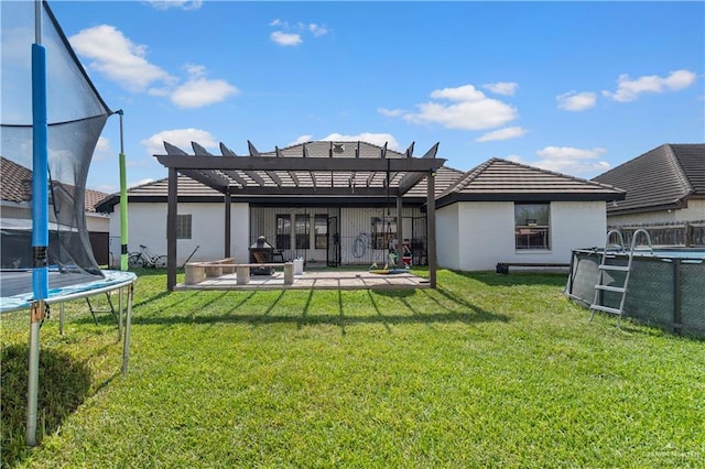 612 Persimmon Ave, Edinburg, TX 78539 - rear view of house with a trampoline, a pergola, a patio area, and a yard