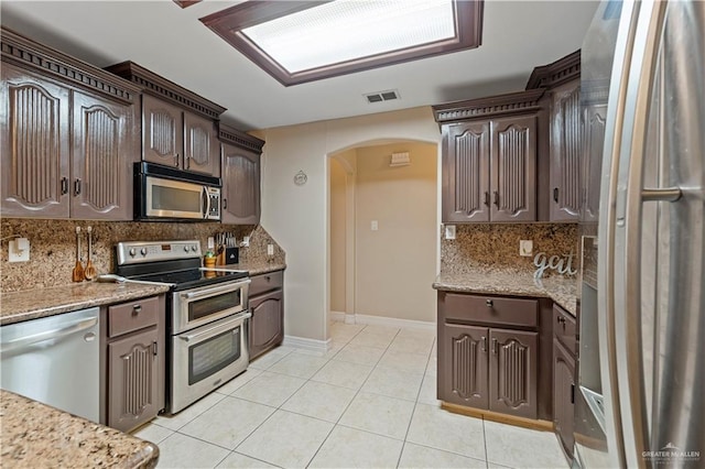 612 Persimmon Ave, Edinburg, TX 78539 - kitchen with stainless steel appliances, arched walkways, dark brown cabinetry, and light tile patterned floors