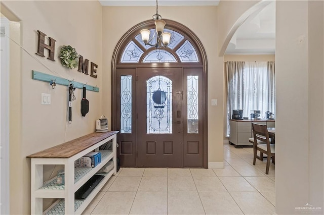 612 Persimmon Ave, Edinburg, TX 78539 - foyer entrance with a chandelier, light tile patterned flooring, and arched walkways