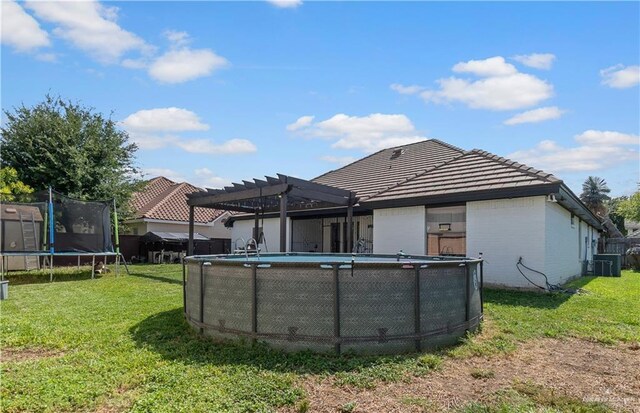 612 Persimmon Ave, Edinburg, TX 78539 - rear view of property featuring a trampoline, a pergola, a lawn, an outdoor pool, and a tile roof