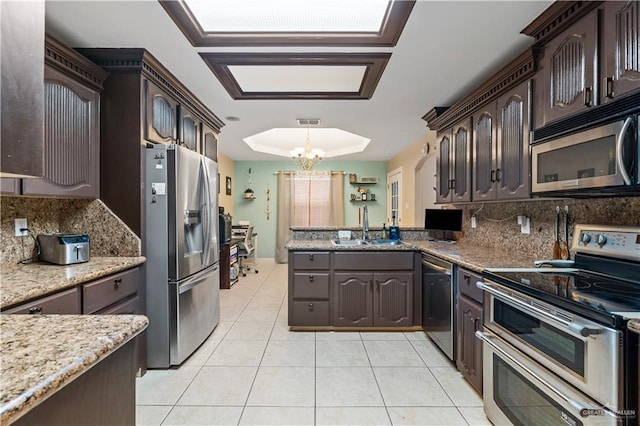 612 Persimmon Ave, Edinburg, TX 78539 - kitchen with stainless steel appliances, a chandelier, tasteful backsplash, and dark brown cabinets