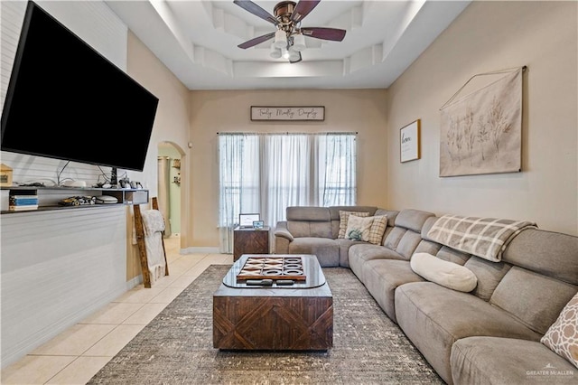612 Persimmon Ave, Edinburg, TX 78539 - living room with light tile patterned flooring, a ceiling fan, arched walkways, a tray ceiling, and a towering ceiling