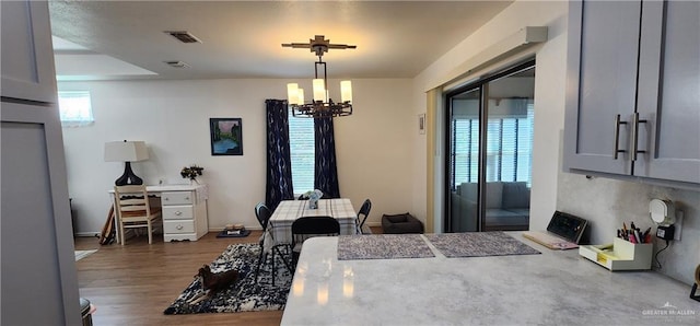 dining area featuring dark wood-type flooring and a chandelier