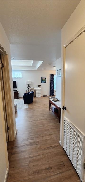 hallway featuring hardwood / wood-style flooring and a skylight