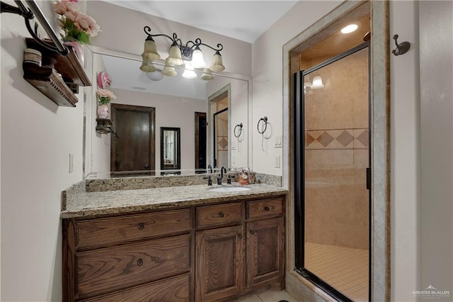 bathroom with a shower with door and vanity