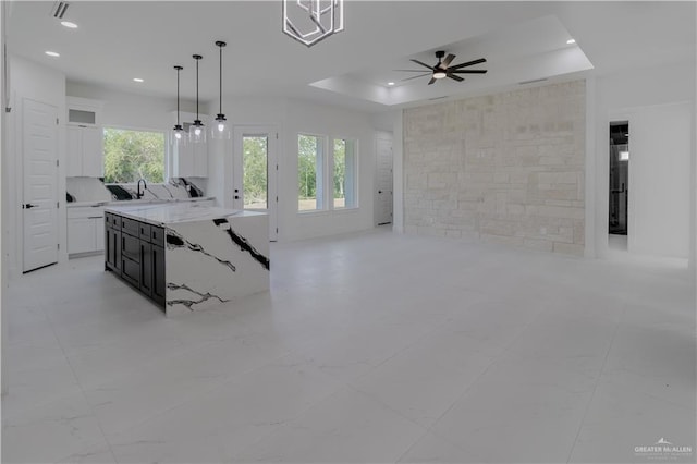 kitchen with open floor plan, white cabinetry, a tray ceiling, and recessed lighting