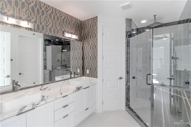 full bath with wallpapered walls, tile patterned floors, double vanity, a sink, and a stall shower