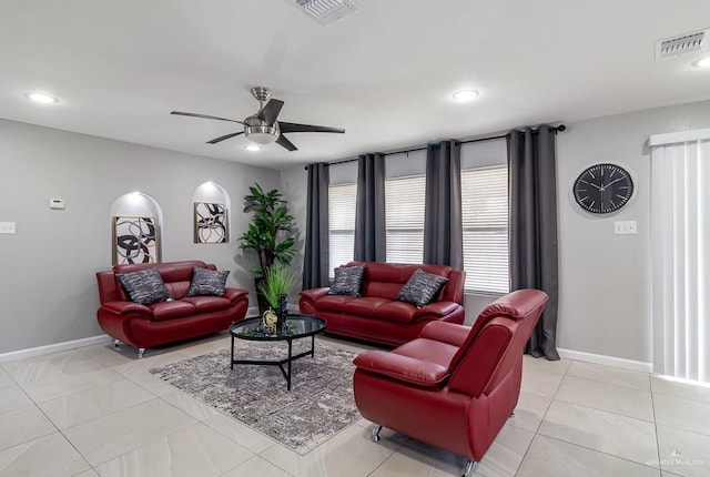 living area featuring ceiling fan, light tile patterned flooring, visible vents, and baseboards