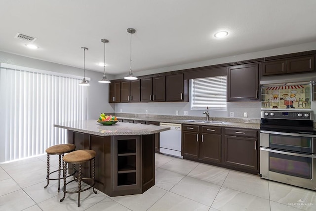 kitchen with range with two ovens, decorative light fixtures, a center island, white dishwasher, and a sink