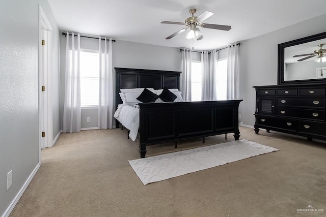 bedroom featuring light carpet, ceiling fan, and baseboards